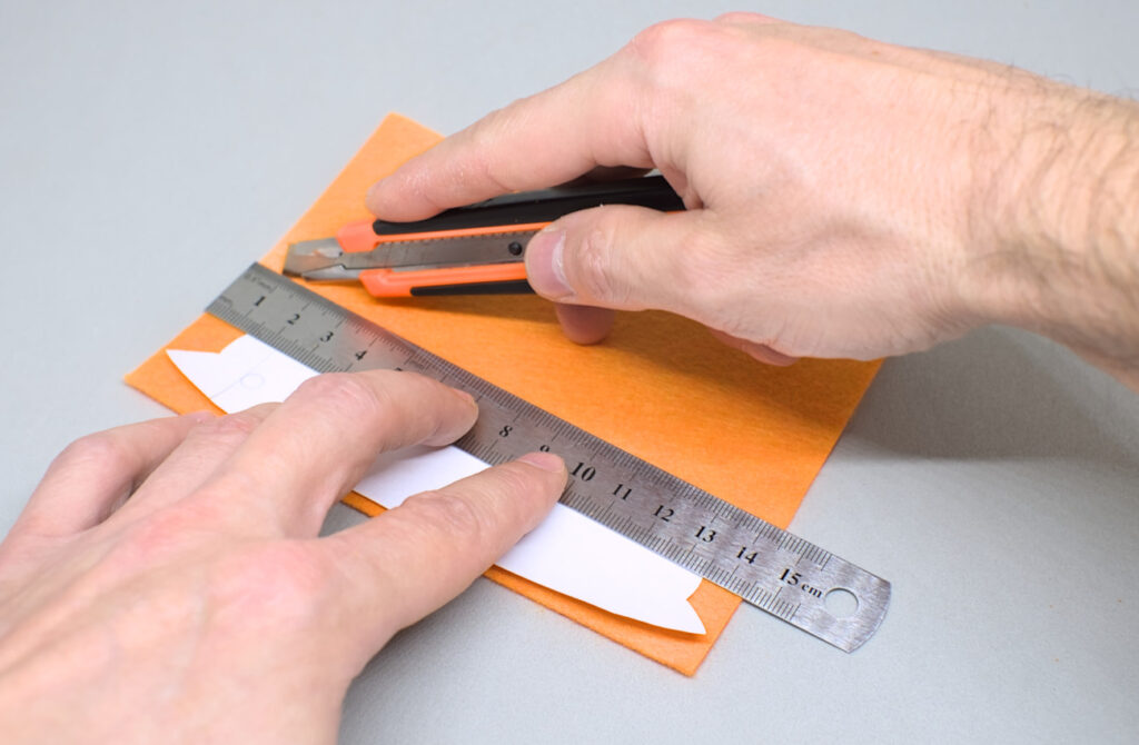 cortando pieza de fieltro para revestir tira de cuero