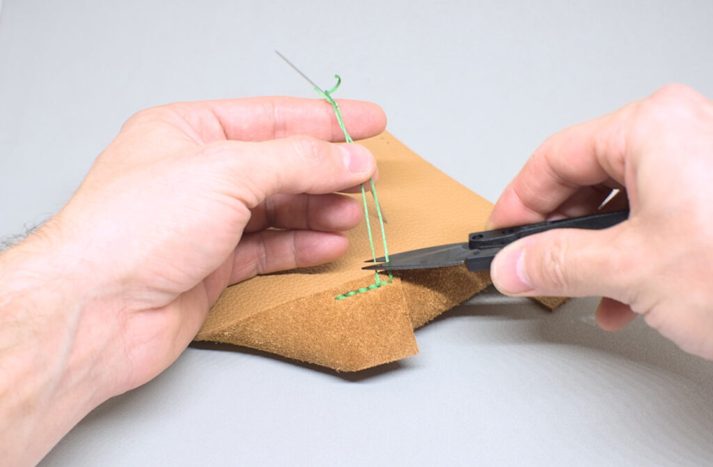 cortando sobrante de hilo encerado de la costura