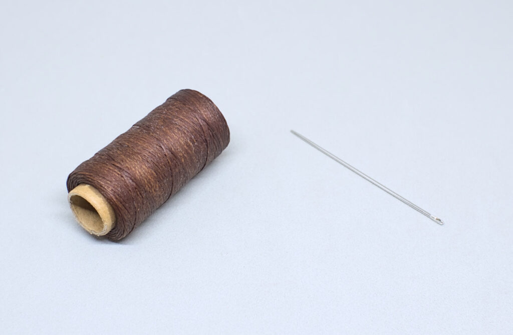 hilo encerado color marron oscuro y aguja recta sin punta
