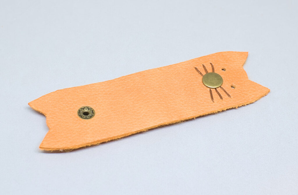 organizador de cables abierto con forma de cabeza de gatito hecho con cuero