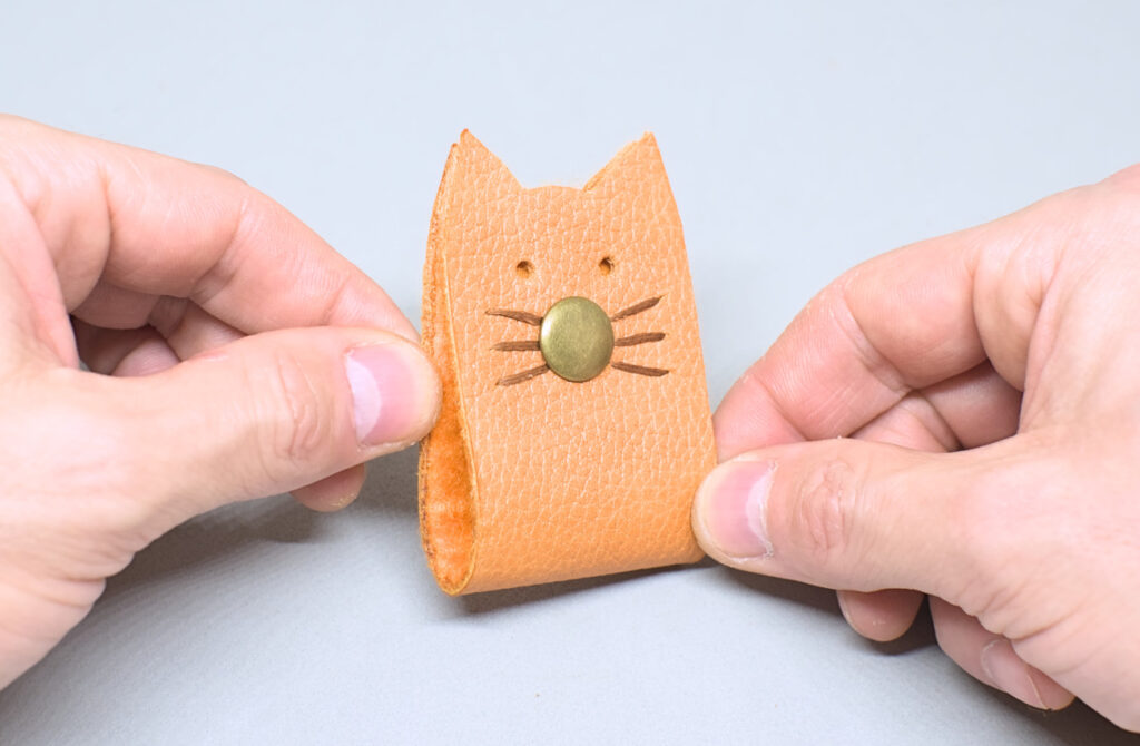 organizador de cables cerrado con forma de cabeza de gatito hecho con cuero