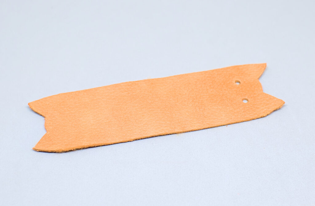 orificios hechos en tira de cuero para representar ojos de gatito