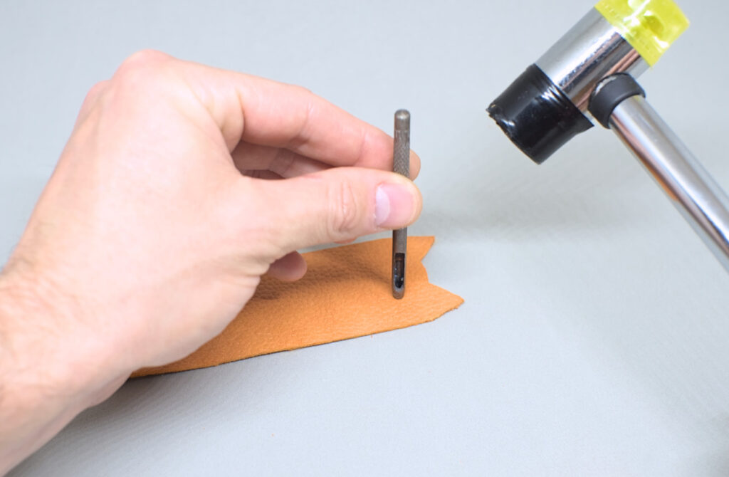 perforando cuero con sacabocados para representar ojos de gatito