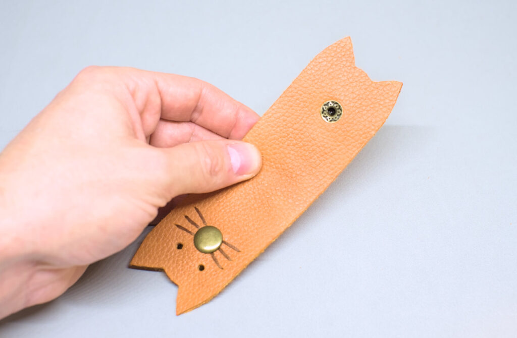 piezas de boton a presion remachadas en organizador de cables de cuero