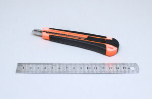 regla de metal y cuter