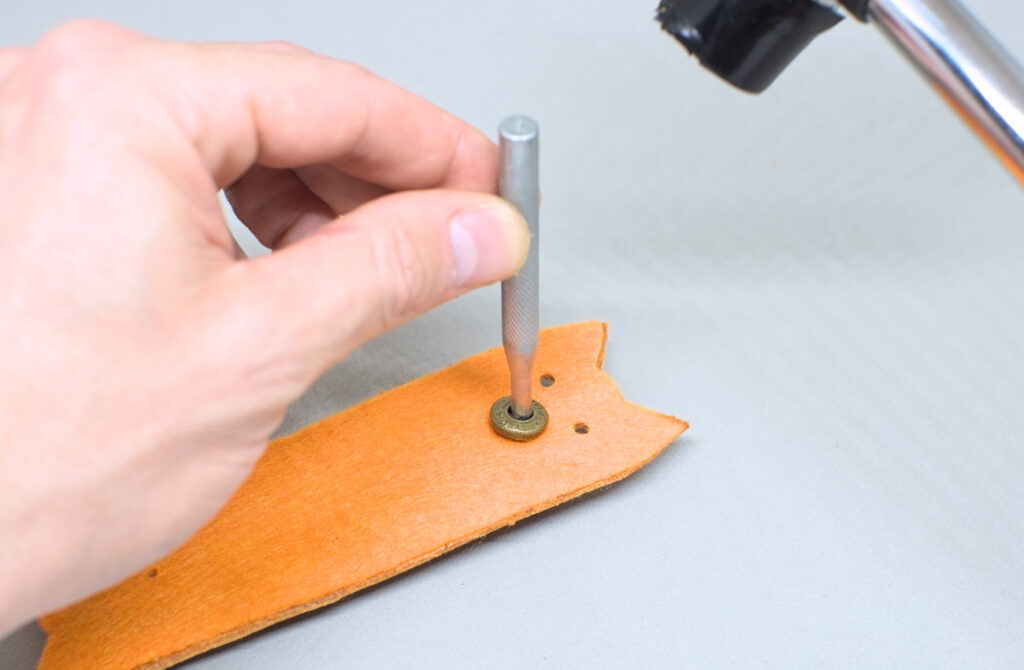 remachando una pieza de boton a presion