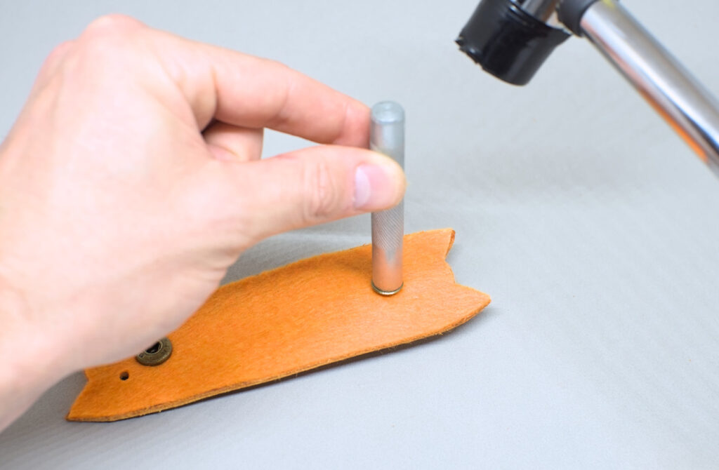 remachando una pieza de broche a presion