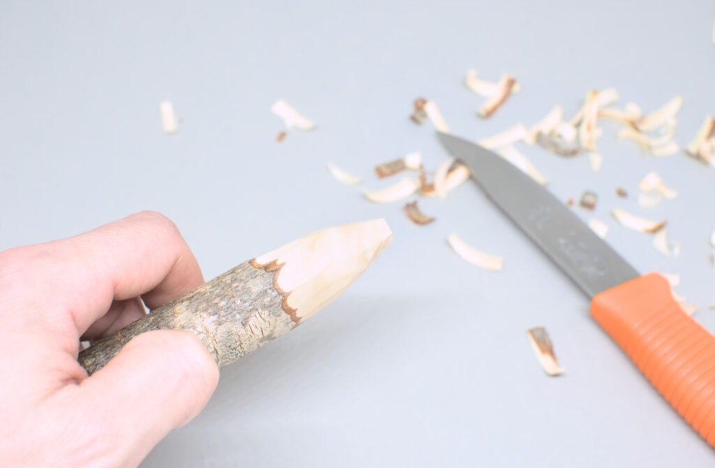 extremo rama de pino de 3 cm diametro tallado con cuchillo carpintero