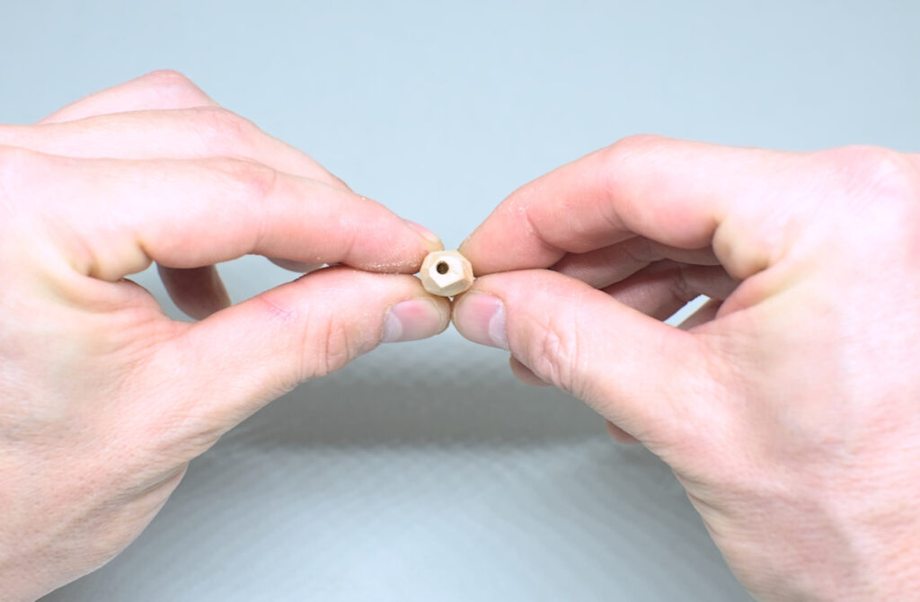 orificio hecho en extremo plano de replica de cristal de cuarzo tallado en madera