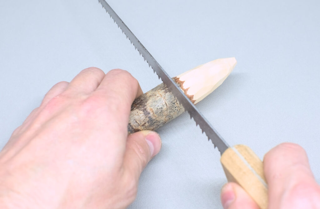 serrando extremo de rama de pino tallado con forma de cono