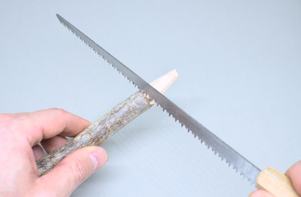 serrando punta tallada de rama seca de pino