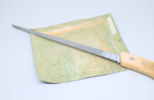 serrucho de mano y papel de lija grano fino