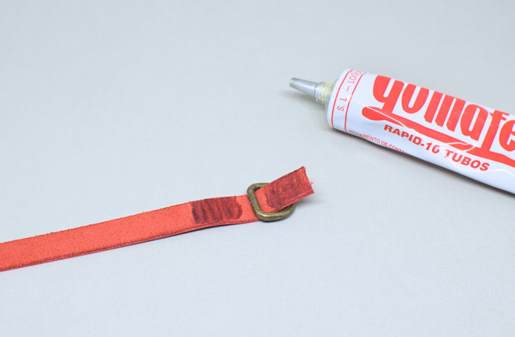 adhiriendo extremo de tira de cuero rojo y semianilla en el centro