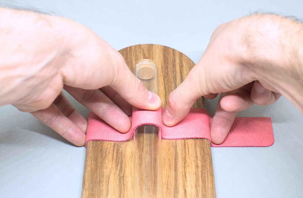 comprobando medida de tira de cuero con tubo de cristal sobre bandeja