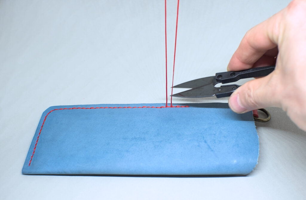 cortando sobrante de hilo encerado