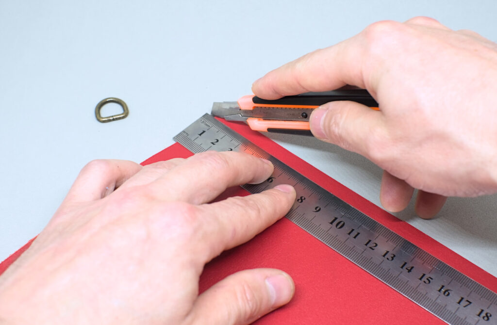 cortando tira de cuero rojo para sujetar semianilla en estuche