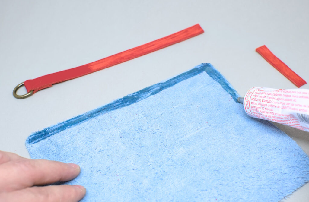 echando pegamento de contacto por contorno de pieza de cuero