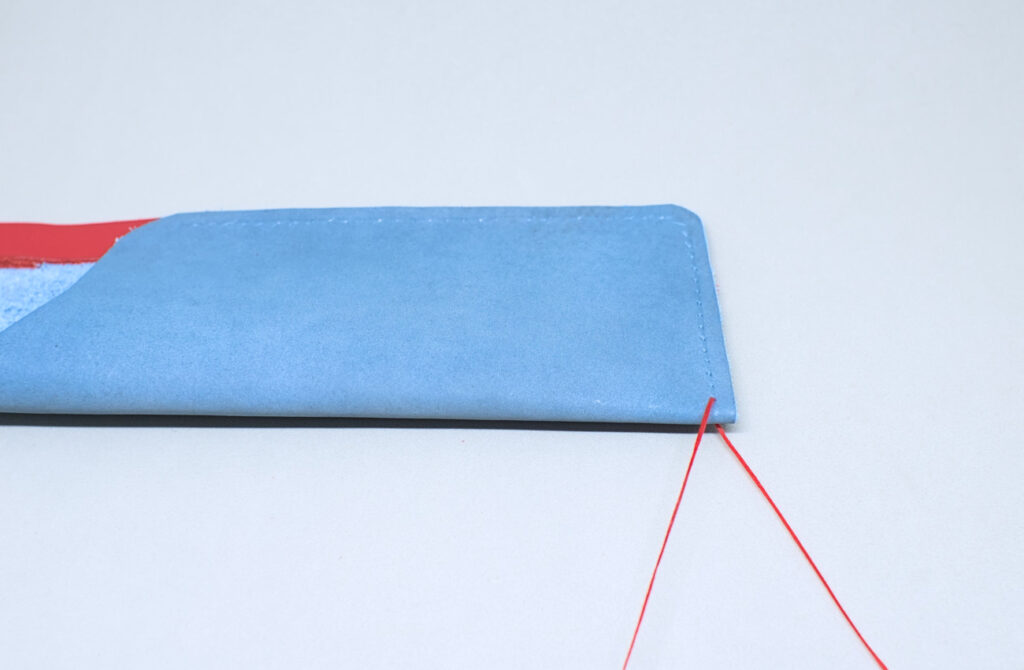 ensartando agujas con hilo encerado para costura en estuche de cuero