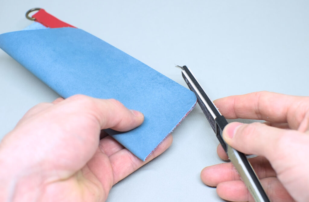 limando contorno de estuche de cuero para gafas