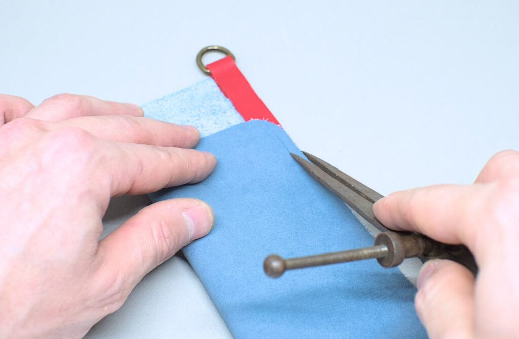 marcando linea de costura en contorno de estuche para gafas con compas para cuero