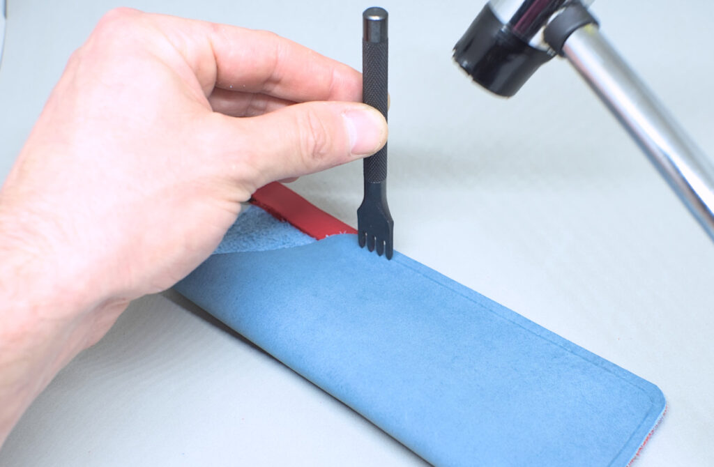 perforando linea de costura con tenedor en estuche de cuero para gafas