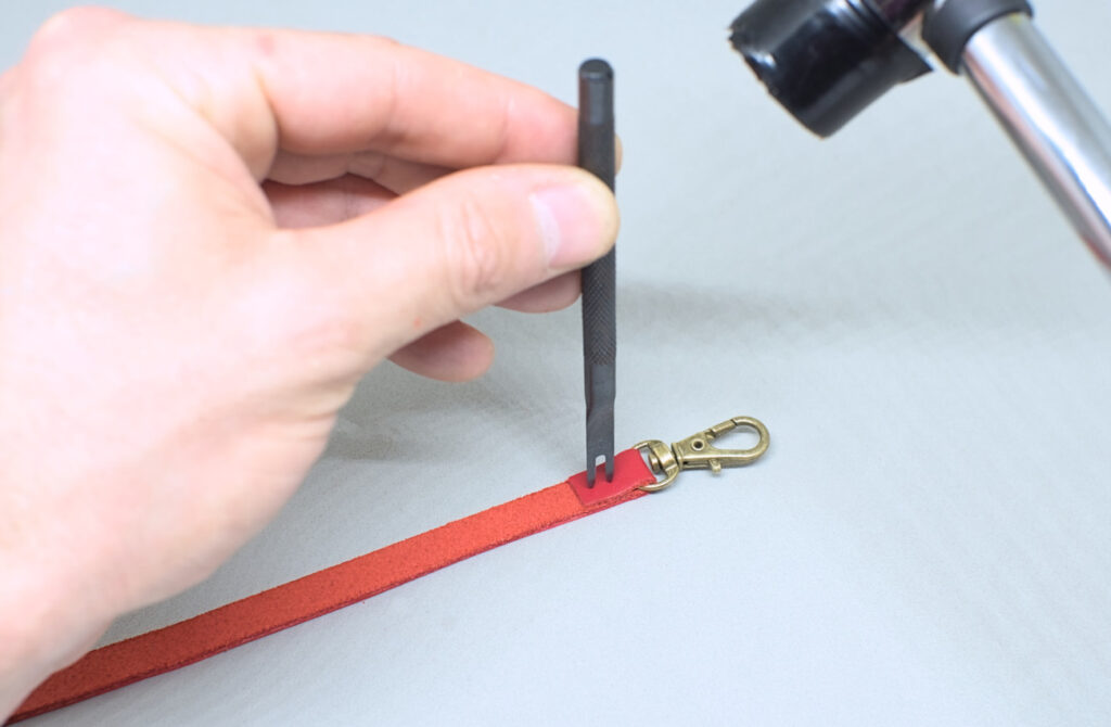 perforando union de correa de cuero con tenedor de dos puntas