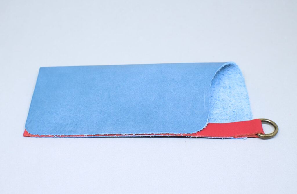 pliego de pieza de cuero azul adherido formando estuche para gafas