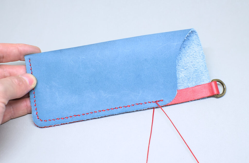 rematando costura con hilo encerado en estuche de cuero