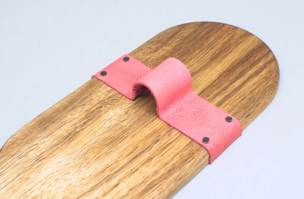 vista lateral de bandeja con tira de cuero y clavos para tapiceria clavados en laterales