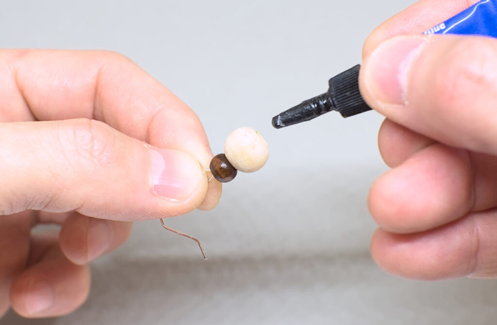 adhiriendo cuentas de madera con pegamento super glue