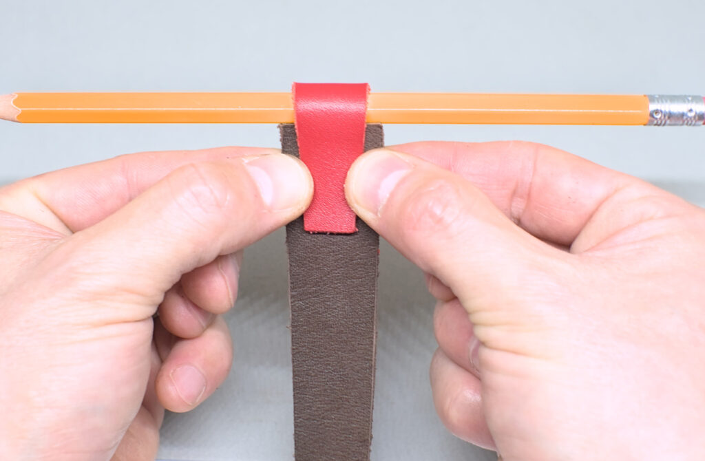 ajustando pieza de cuero del portalapices del marcapaginas