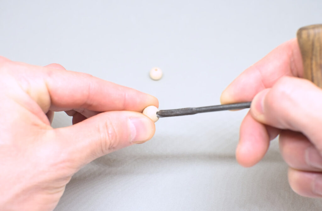 ampliando agujero de cuenta de madera con barrena de mano