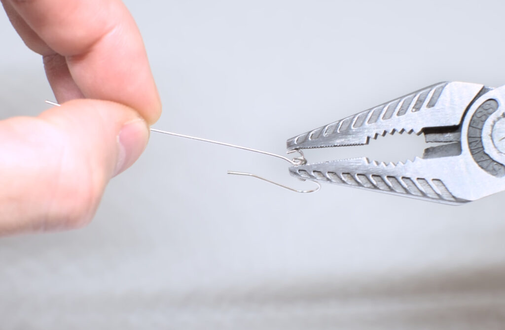 cerrando ojo abiero de alfiler con gancho de pendiente con alicates