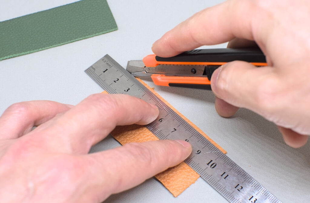 cortando finas de tiras de cuero