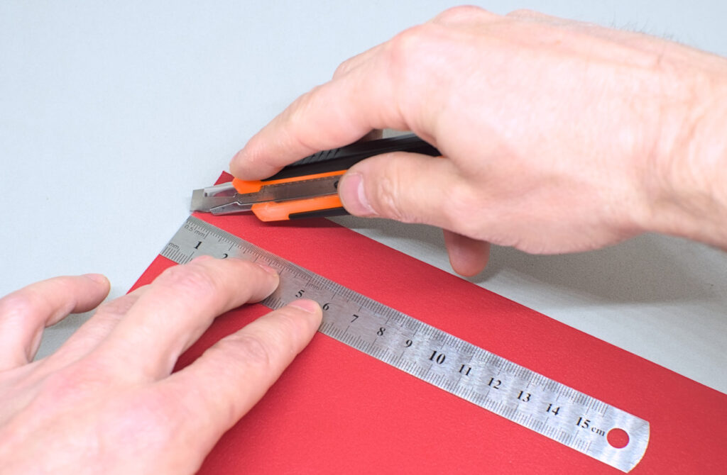 cortando pequeña tira de cuero rojo