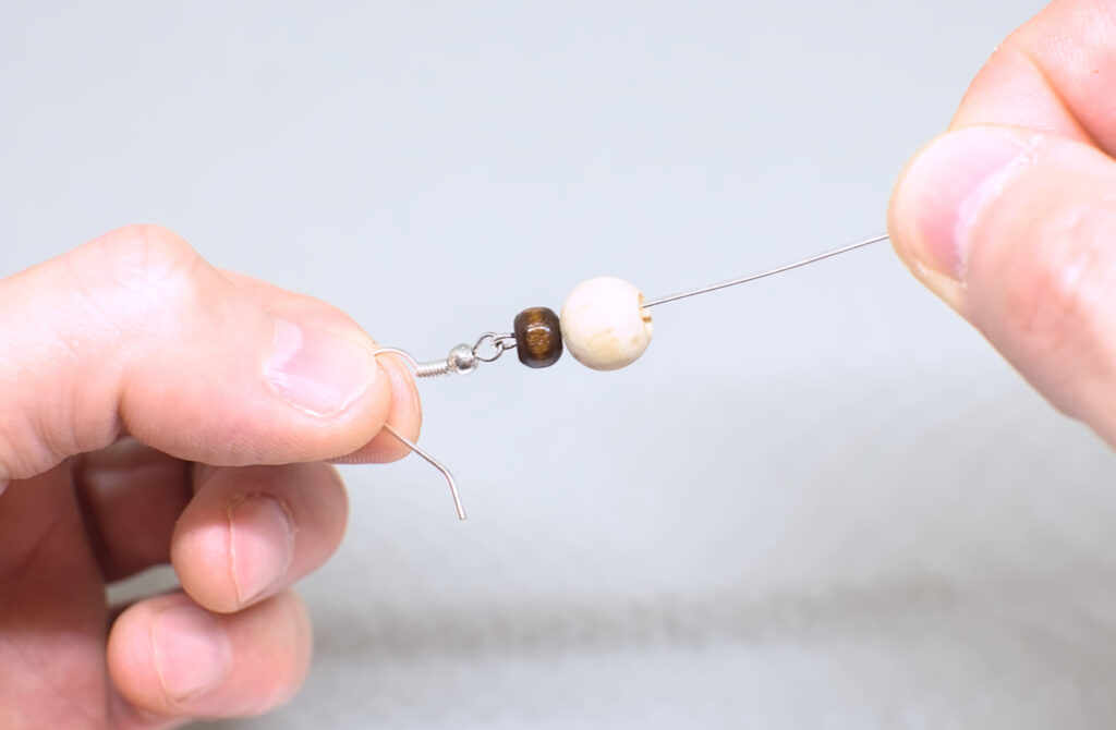 cuentas de madera ensartadas en alfiler con gancho para pendientes