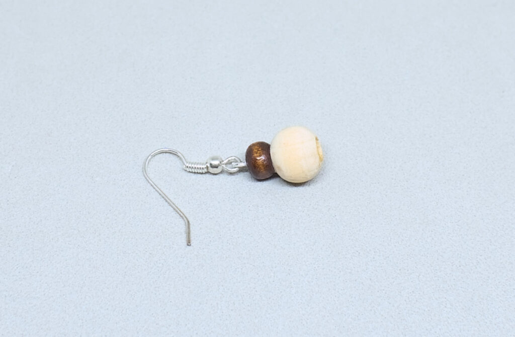 gancho de metal con alfiler y cuentas de madera adheridas