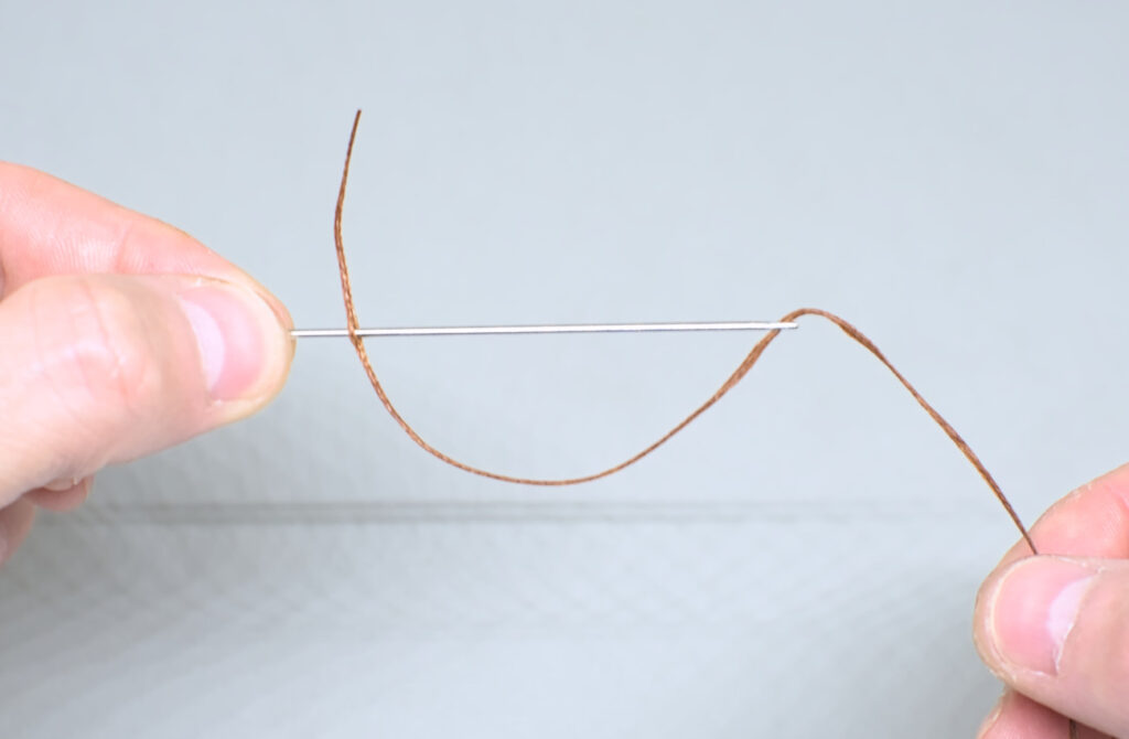 hilo encerado ensartado en aguja