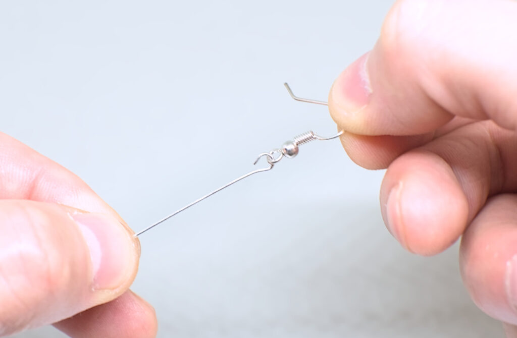 introduciendo gancho de pendiente en ojo abierto de alfiler