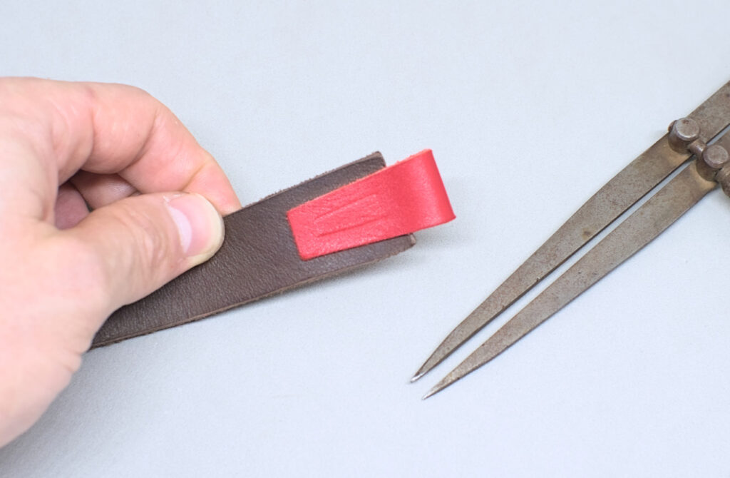 lineas de costura marcadas en pieza de cuero rojo