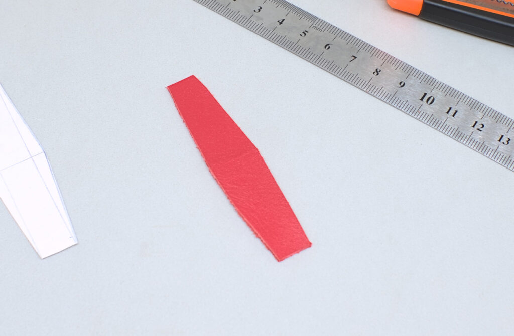 pequeña pieza de cuero rojo con forma de rombo