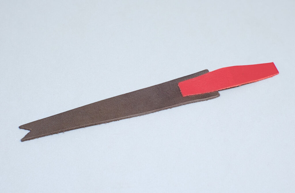 pieza de cuero rojo adherida sobre tira de cuero de marcapaginas