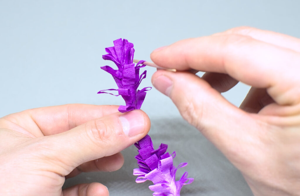 abriendo flecos de tiras de papel crespon con palillo
