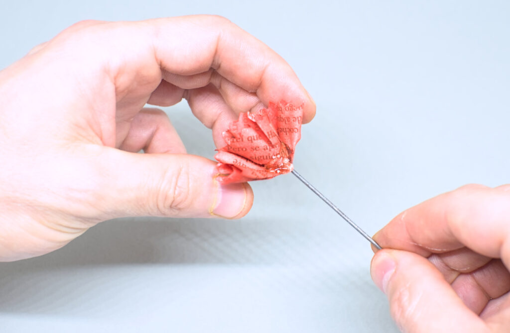 adhiriendo por el contorno del cucurucho seguda pieza de papel para formar clavel rojo