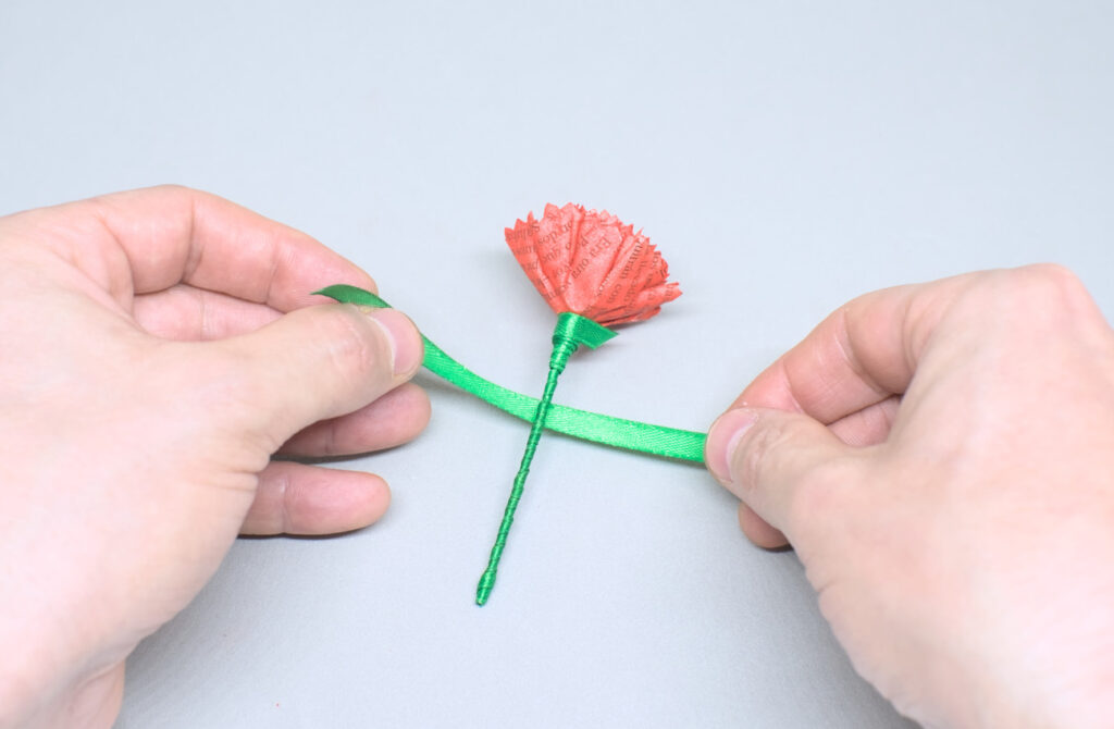 anunando trozo de cibta de raso para hacer las hojas de la flor de clavel