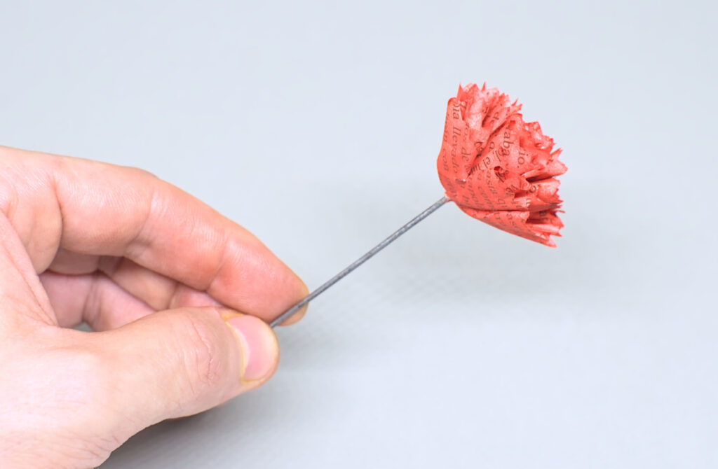 colocadas todas las piezas de papel que forman una flor de clavel rojo