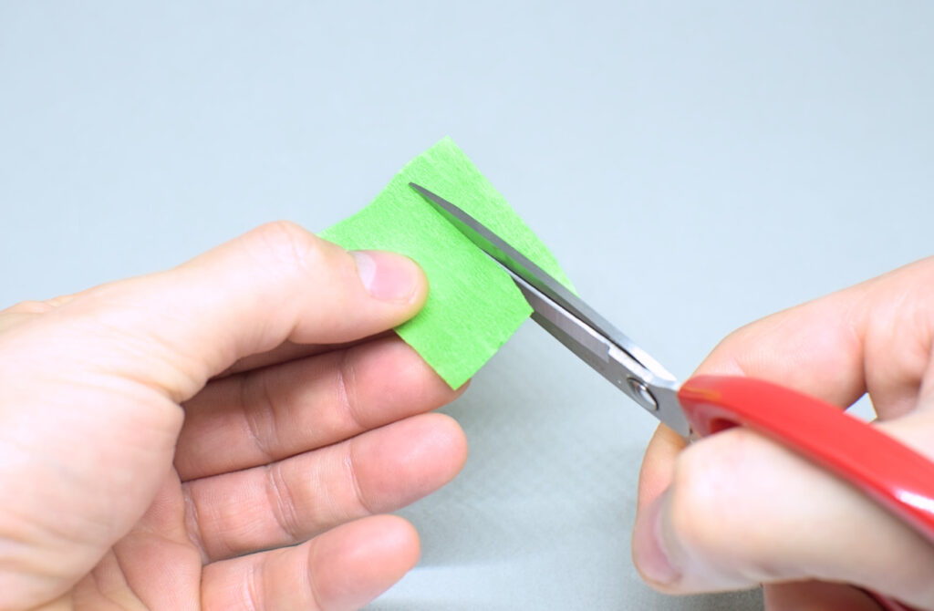 corte de figura simetrica en trozo de papel crespon verde