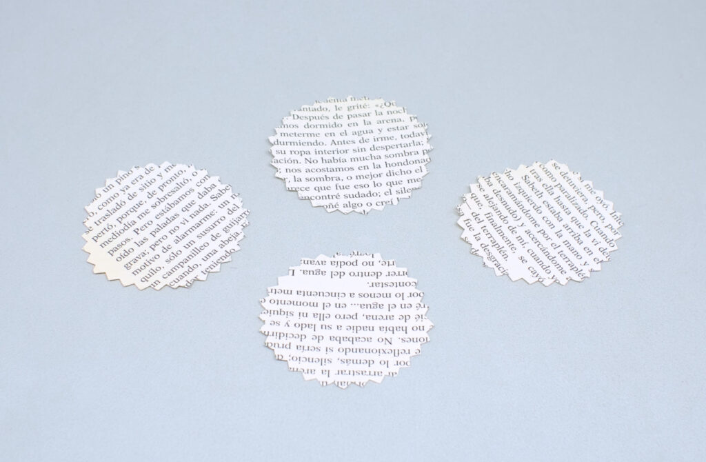 cuatro circulos de papel de libro cortados con tijera dentada