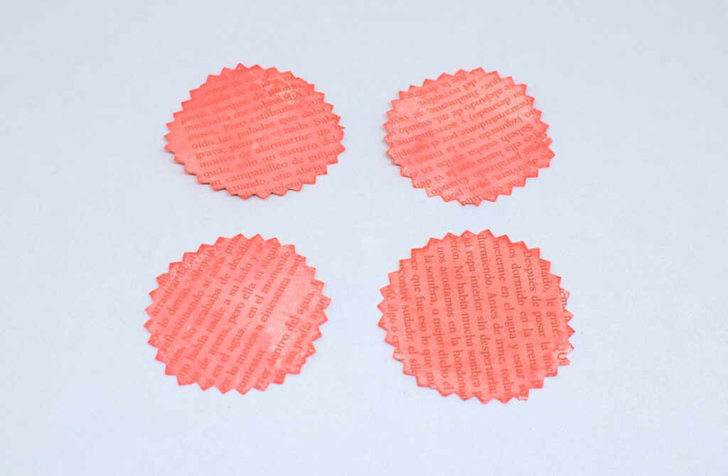cuatro circulos dentados de papel pintados en color rojo