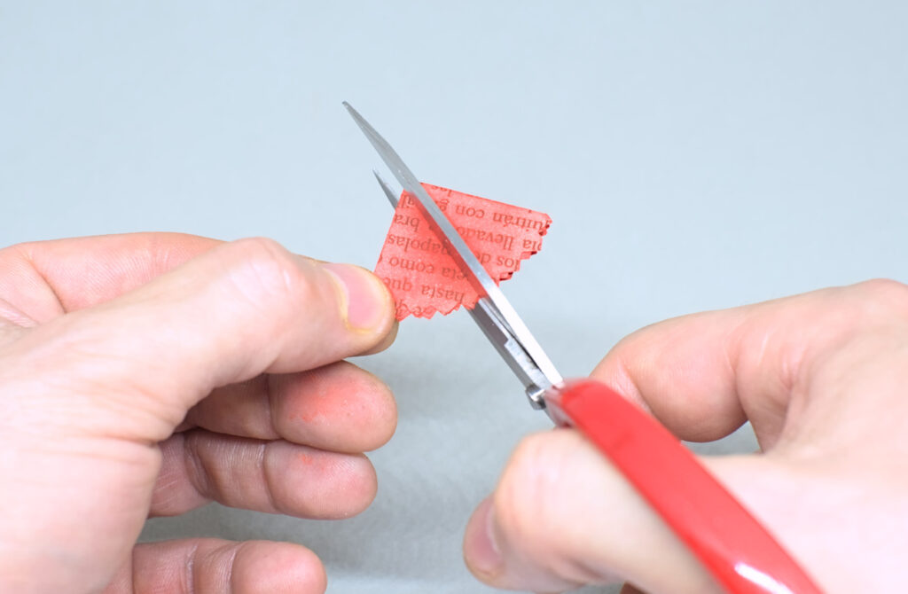 haciendo corte con tijeras en la mitad del circulo de papel doblado